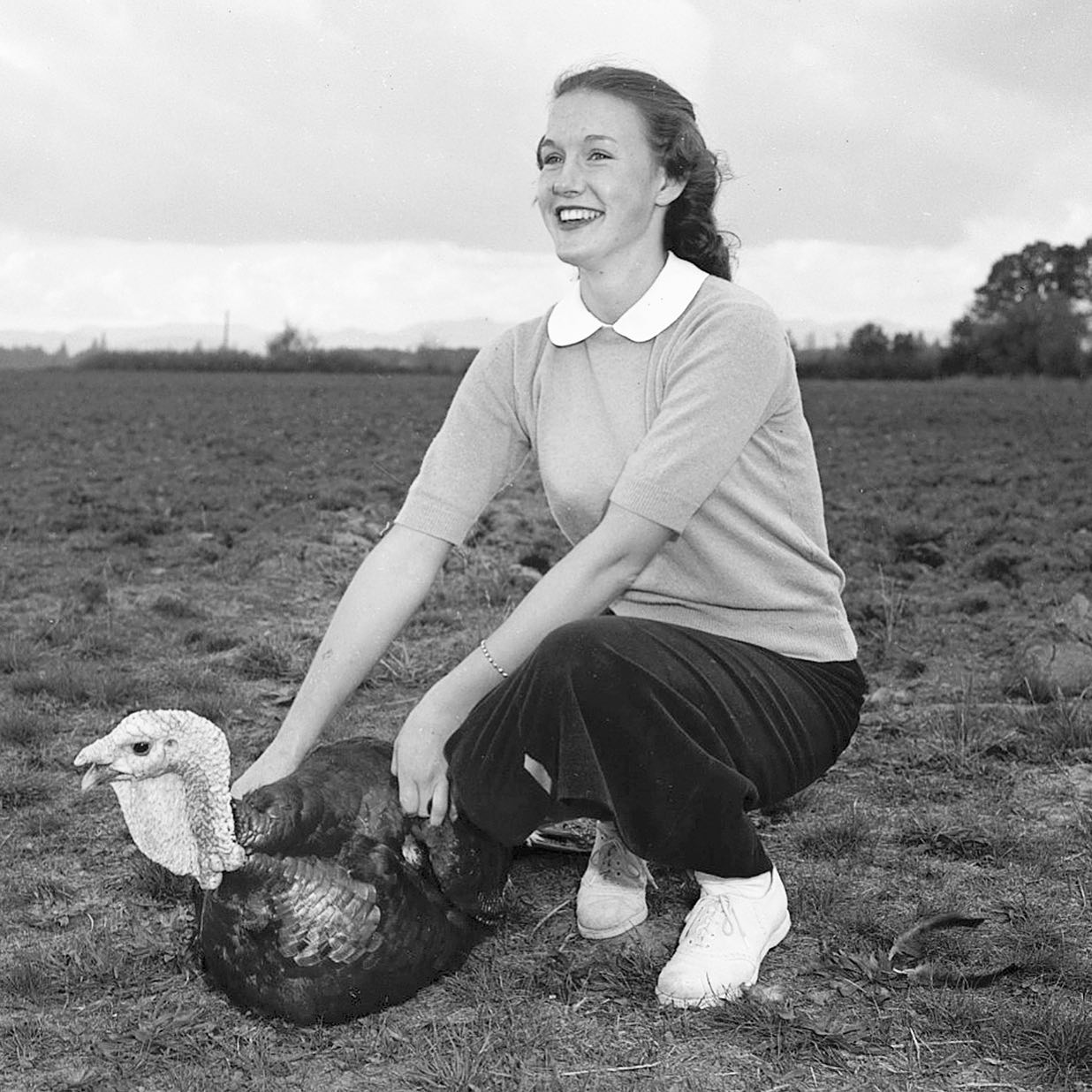 Young woman holding a turkey.